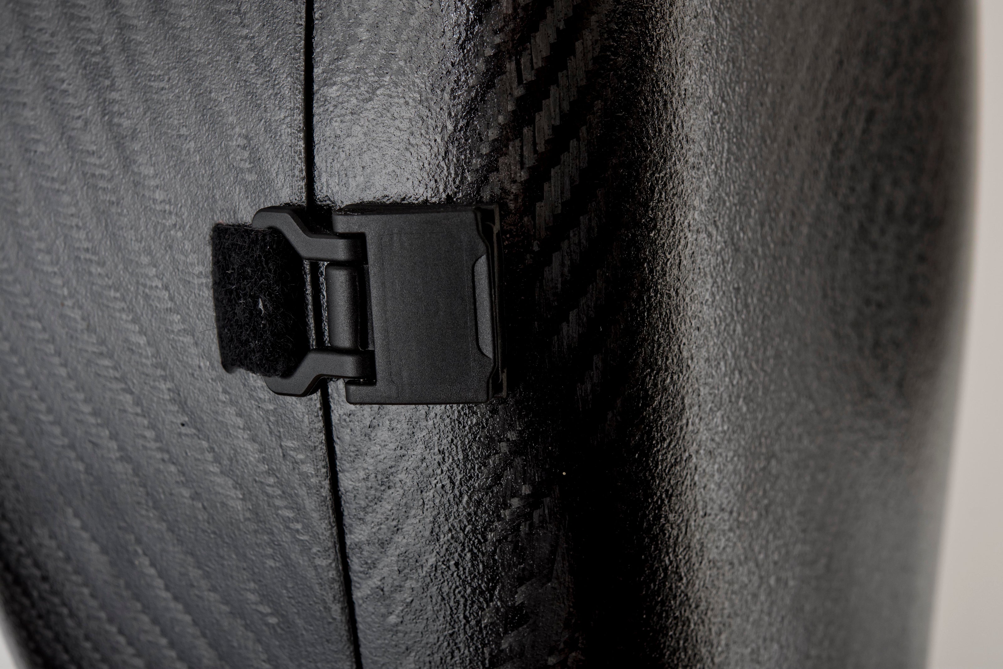 Close-up of a black magnetic latch on a cello case head
